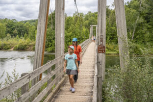 Mother and daughter crossing suspension bridge