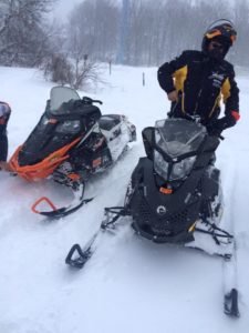 man snowmobiling in winter in manistee county