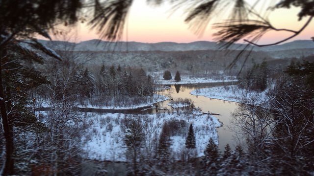 View of river in winter at sunset
