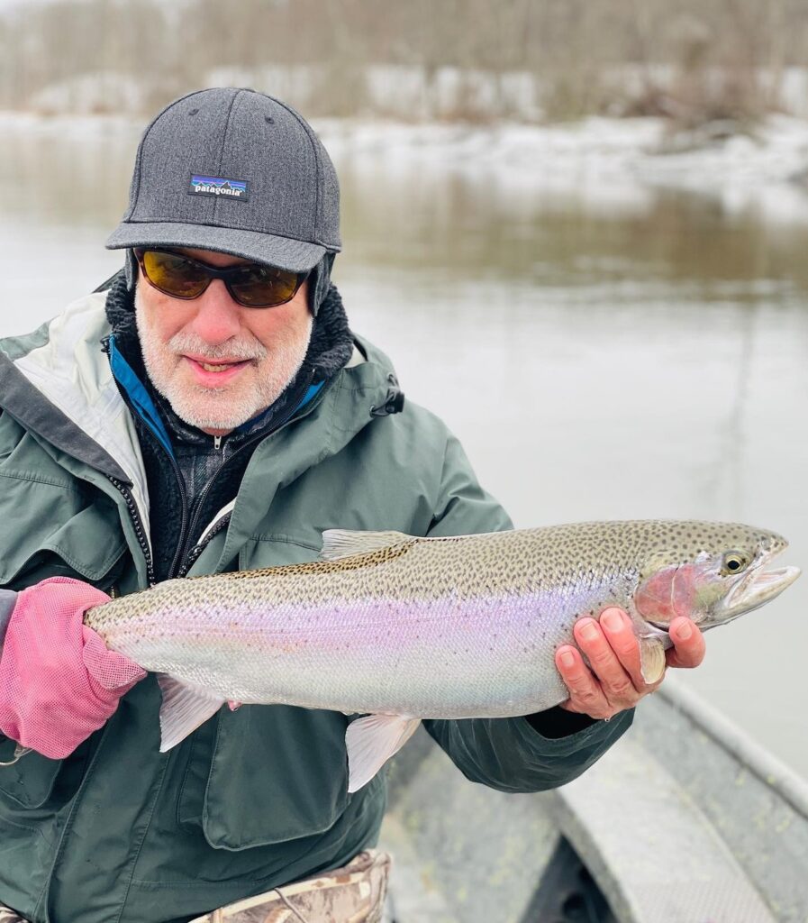 Man holding fish winter river fishing