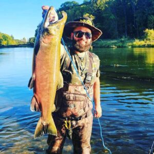 Man holding up fish caught in Manistee River