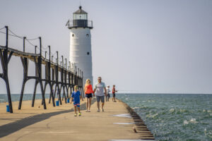 People walking on the pier from lighthouse