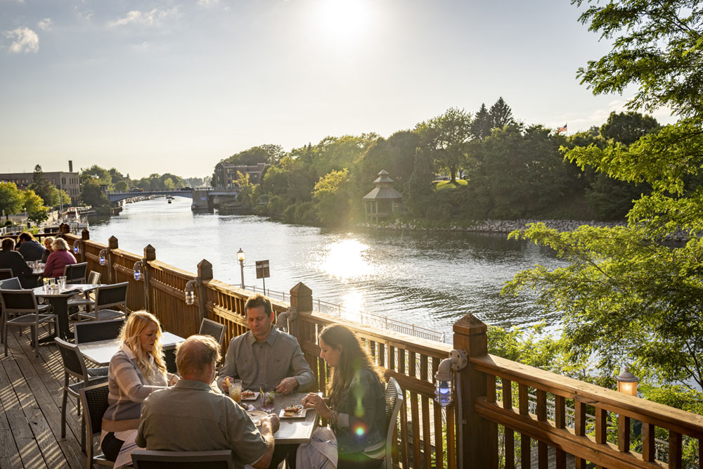 Manistee-48779 People dining on the deck overlooking the river at The Blue Fish Kitchen + Bar
