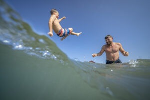Father and son playing in the waves