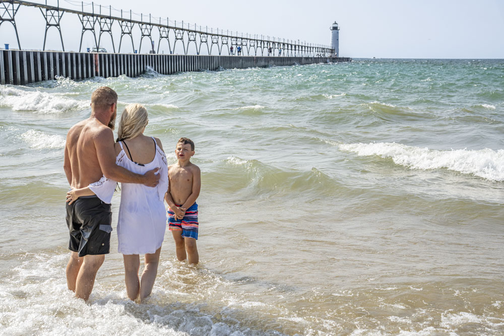 Family standing gin Lake Michigan by Manistee pier