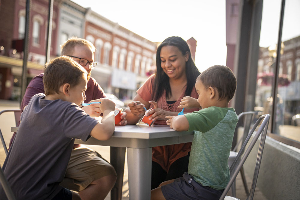 Manistee-48915 Family sitting at outdoor table eating ice cream