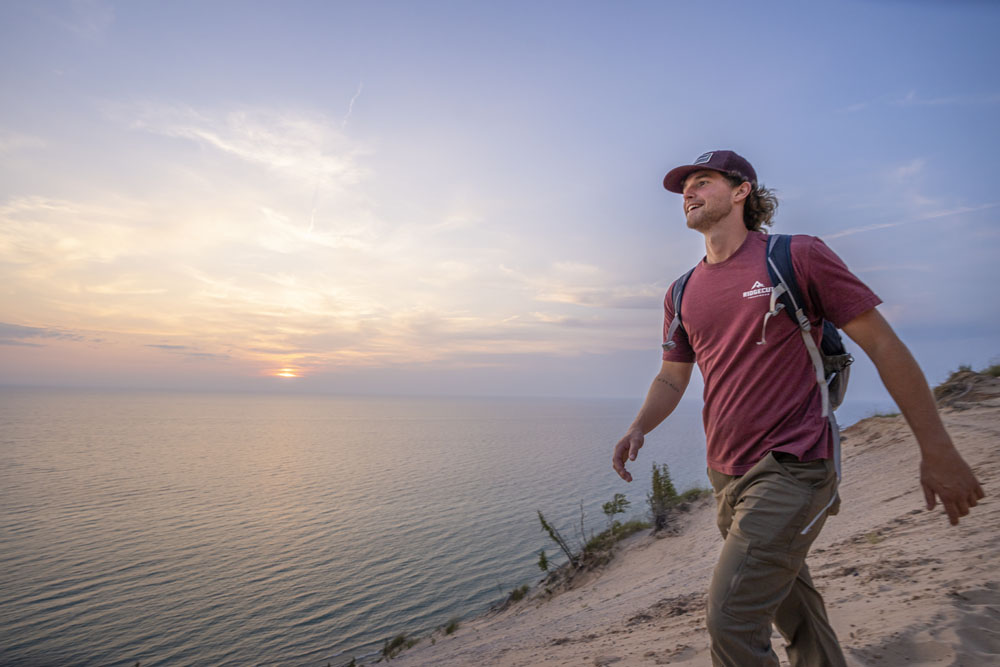 Hiking to and on the Baldy Dune at Arcadia Dunes nature preserve. Man walking across dune