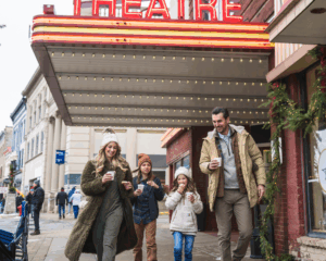 Family walking in front of Vogue Theater dressed in winter clothes
